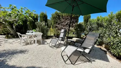 a table and chairs with a green umbrella at Residence Cavalluccio Marino in Alcamo Marina