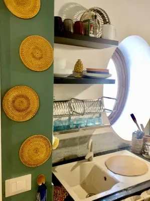 a kitchen with a sink and plates on a green wall at Cathedral cozy apartment in Palermo
