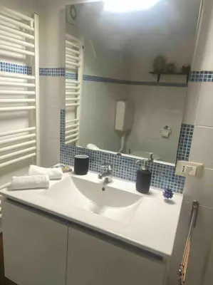 a bathroom with a white sink and a mirror at Cathedral cozy apartment in Palermo