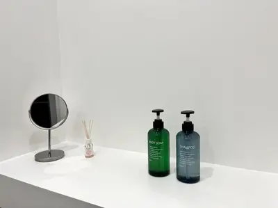 two bottles of shampoo and a mirror on a bathroom counter at Lazio apartment nel centro di Palermo in Palermo
