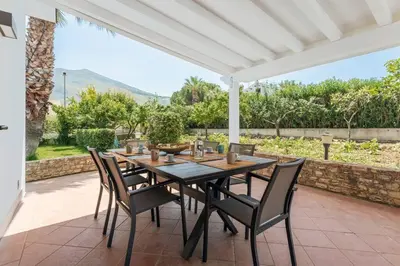 a dining room with a table and chairs on a patio at Villa NìMia in Castellammare del Golfo