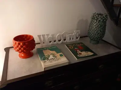 a table with two books and a vase on it at Casa Bosco a Ballarò in Palermo