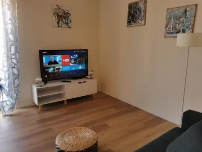 a living room with a flat screen tv on a cabinet at Holiday House Nonna Grazia in Trappeto