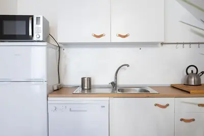 a white kitchen with a sink and a microwave at Cavour Elegant apartment At Massimo Theater in Palermo