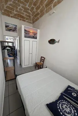 a bedroom with a bed and a chair in it at 'a casetta - Sferracavallo in Palermo