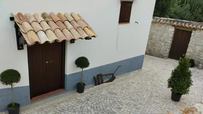 a building with a wooden door and two potted plants at Fattoria F.lli Marsolo in Chiusa Sclafani