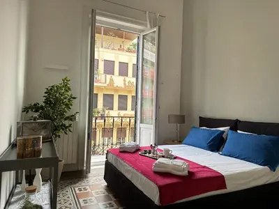 a bedroom with a bed and a large window at Victoria's Apartment in Palermo