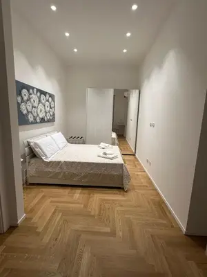 a bedroom with a bed and a wooden floor at Lily Suite in Palermo