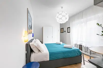 a bedroom with a bed with a blue blanket at GuestHost - Teatro Massimo Modern Studio in Palermo