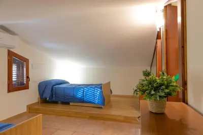 a bedroom with a bed and a table with a plant at Villa Seaside in Campofelice di Roccella