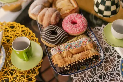 a table with a tray of donuts and cups of coffee at Villa Seaside in Campofelice di Roccella