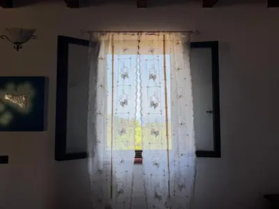 a window with white curtains in a room at Le Casette di campagna #2 in Campofelice di Roccella