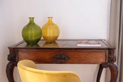 three vases sitting on top of a table with a chair at Ermosa Suite in Palermo