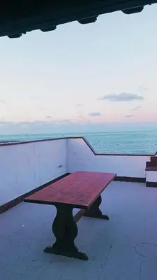 a picnic table sitting on top of a building overlooking the ocean at LA TERRAZZA SUL MARE monolocale con terrazza vicino aereoporto&mare SICILIAN VINTAGE STYLE BEACH HOUSE in Cinisi