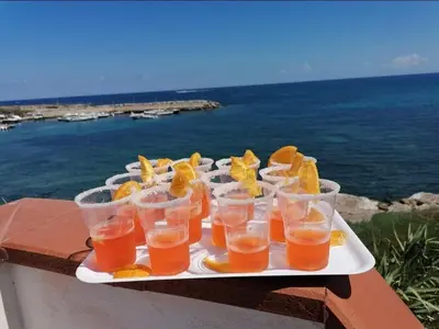a tray of drinks on a table near the ocean at LA TERRAZZA SUL MARE monolocale con terrazza vicino aereoporto&mare SICILIAN VINTAGE STYLE BEACH HOUSE in Cinisi