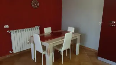a dining room with a table and white chairs at Holiday Home Villa Relax in Palermo