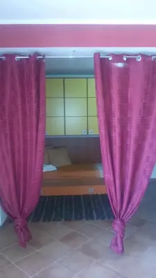two pink curtains in a room with a bed at Holiday Home Villa Relax in Palermo