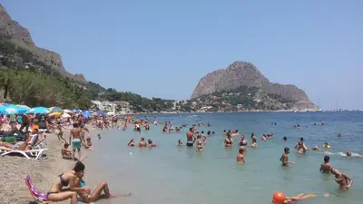 a group of people in the water at a beach at Holiday Home Villa Relax in Palermo
