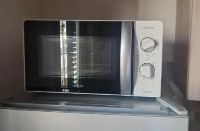 a microwave oven sitting on top of a refrigerator at Politeama Holiday Home - La tua casa nel cuore di Palermo! in Palermo