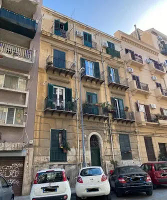 a building with cars parked in front of it at Politeama Holiday Home - La tua casa nel cuore di Palermo! in Palermo