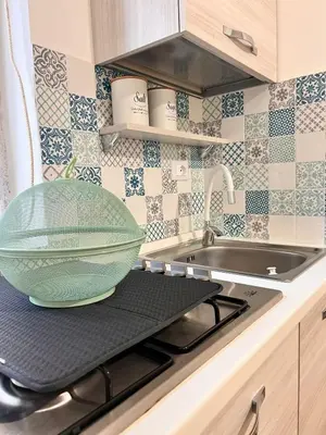 a green bowl sitting on top of a stove in a kitchen at Casa Gabriele in Palermo