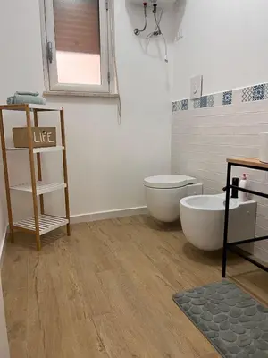 a bathroom with a tub and a toilet and a mirror at Casa Gabriele in Palermo