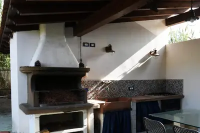 an outdoor pizza oven in a patio with a table at Villa Maruzza (Sicilia Bedda) in Carini