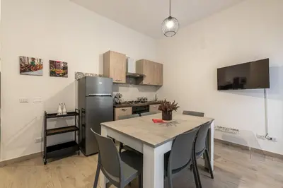 a kitchen with a table and a stainless steel refrigerator at Casa Brunaccini con Terrazza by Wonderful Italy in Palermo
