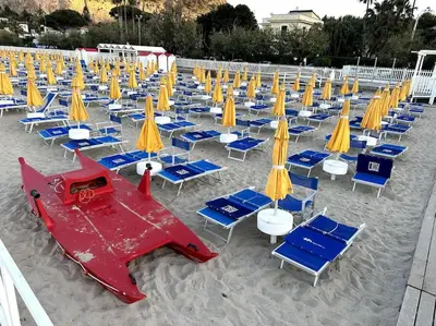a bunch of chairs and umbrellas and beach chairs at Casa Vacanza Mondello in Palermo