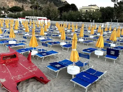 a bunch of chairs and umbrellas on a beach at Casa Vacanza Mondello in Palermo