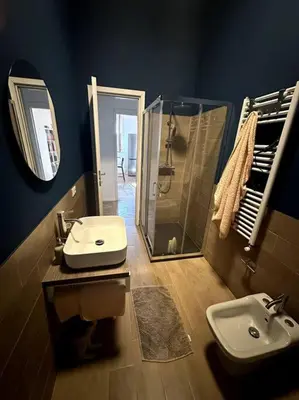 a bathroom with a sink and a shower and a mirror at Casa Vacanza Mondello in Palermo