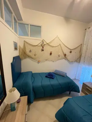 a living room with a blue couch in a room at Le finestre sul mare in Santa Flavia
