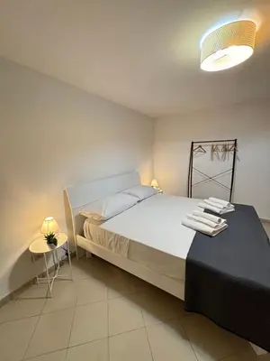 a bedroom with a bed and a table with towels on it at A Due Passi da Mondello in Palermo