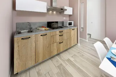 a kitchen with wooden cabinets and a sink at I Tre Golfi - Residenza Cala Azzurra in San Vito lo Capo