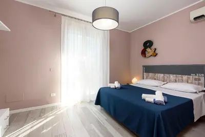 a bedroom with a blue bed with two pillows on it at I Tre Golfi - Residenza Cala Azzurra in San Vito lo Capo