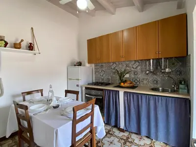 a kitchen with a table with a white table cloth at Le Case di Anan, Castellammare del Golfo in Castellammare del Golfo