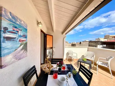 a patio with a table and chairs on a balcony at Le Case di Anan, Castellammare del Golfo in Castellammare del Golfo