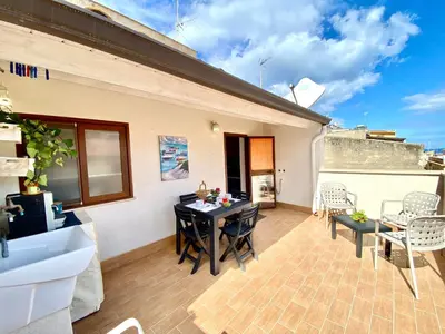 a patio with a table and chairs on a building at Le Case di Anan, Castellammare del Golfo in Castellammare del Golfo
