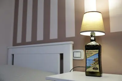 a bottle of wine sitting on a table with a lamp at Casa di Paola in Palermo