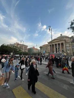 a group of people crossing a street in a city at Casa di Paola in Palermo