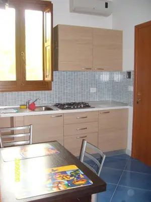 a kitchen with a table and a stove top oven at casa cocos in San Vito lo Capo