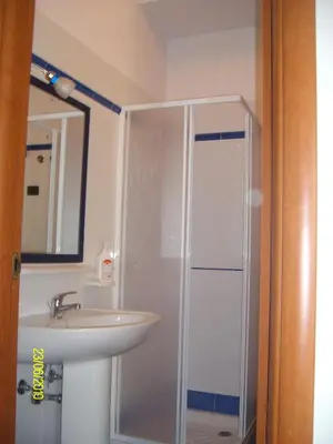 a bathroom with a shower and a sink and a mirror at casa cocos in San Vito lo Capo