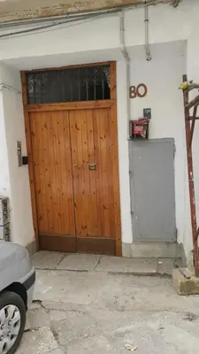 a wooden door of a house with a car parked in front at Kappa's house in Palermo