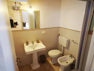 a bathroom with a sink and a toilet and a mirror at Kappa's house in Palermo