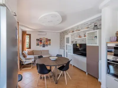 a kitchen and living room with a table and chairs at Villa Kamarà in Castellammare del Golfo