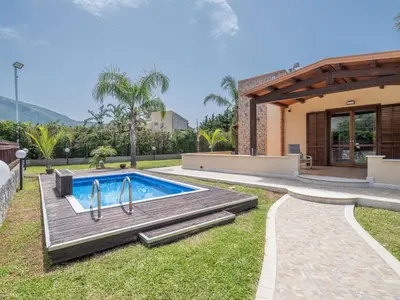 a backyard with a swimming pool and a house at Villa Kamarà in Castellammare del Golfo