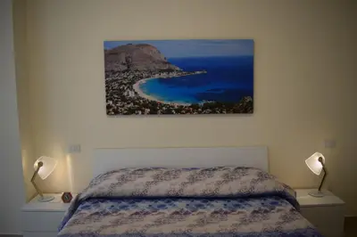 a bedroom with a bed and a painting on the wall at La Casa di Gus in Palermo
