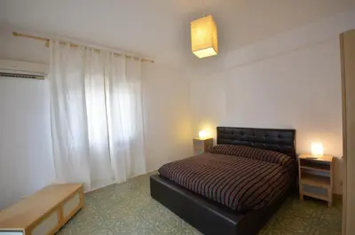a small bedroom with a bed and a window at Casa Garofani in Carini