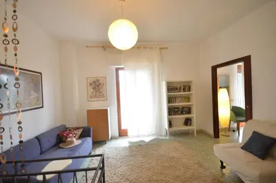 a living room with a blue couch and a window at Casa Garofani in Carini