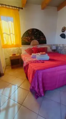 a bedroom with a bed with red sheets and a window at Casetta vista mare 2 Climatizzata in Castellammare del Golfo